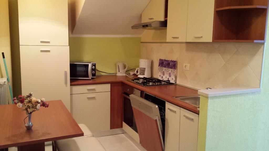 A compact kitchen with a microwave, coffee maker, and dishwasher.