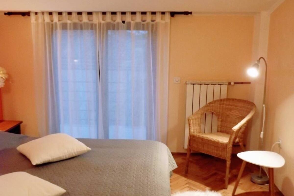 Une chambre à coucher avec un lit, une chaise, une table et un radiateur.