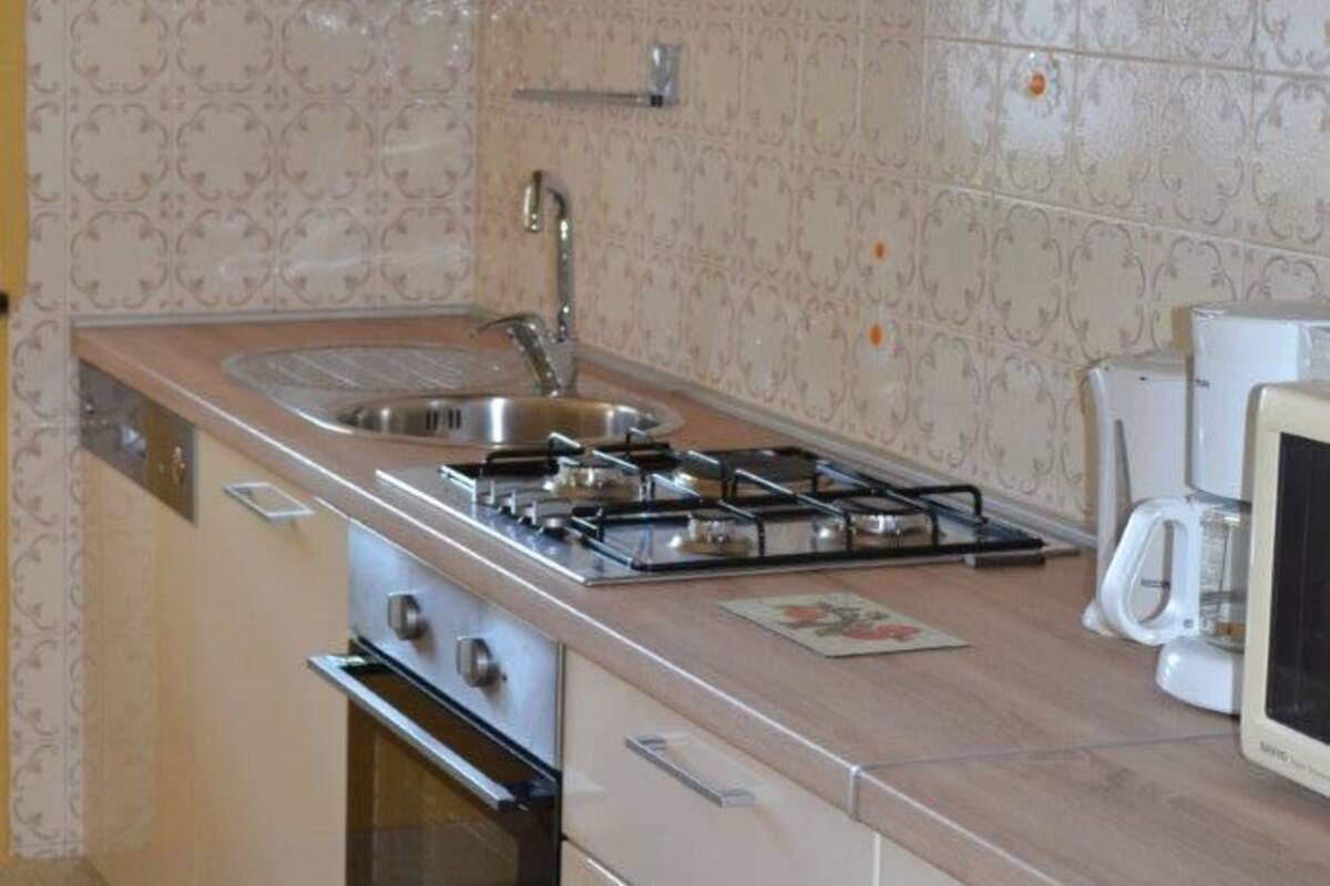 Une cuisine de taille réduite équipée d’une cuisinière à gaz, d’un four et d’un four à micro-ondes.
