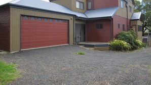 A two-story house with a red garage door, a front porch, and a driveway. - Central Holiday House at 29 Church in Cowes (Cowes)