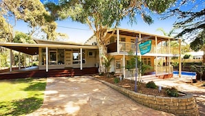 A two-story house with a covered porch, a sign indicating 'Family Holiday Units', and a stone pathway leading to the entrance. - Beach House Units - 2 (Cowes)