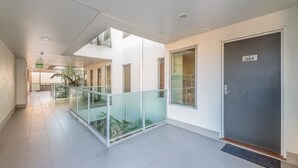 Ein modernes Gebäude mit einem Glasbalkon, einer Tür mit der Aufschrift „344“ und einem gefliesten Boden.