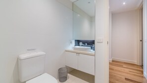A modern bathroom with a toilet, sink, and mirror.