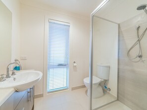 A modern bathroom with a glass shower enclosure, a toilet, and a sink with a mirror. - Genesta 5B House in Cowes (Cowes)