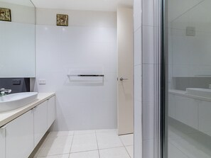 A modern bathroom with a white sink, mirror, and tiled floor.
