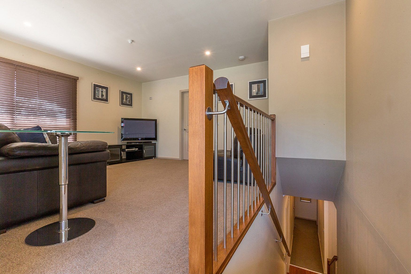 A living room with a sofa, TV, and entertainment unit.