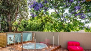 Ein Bereich mit Whirlpool, Holzterrasse und einem roten Sitzsack.