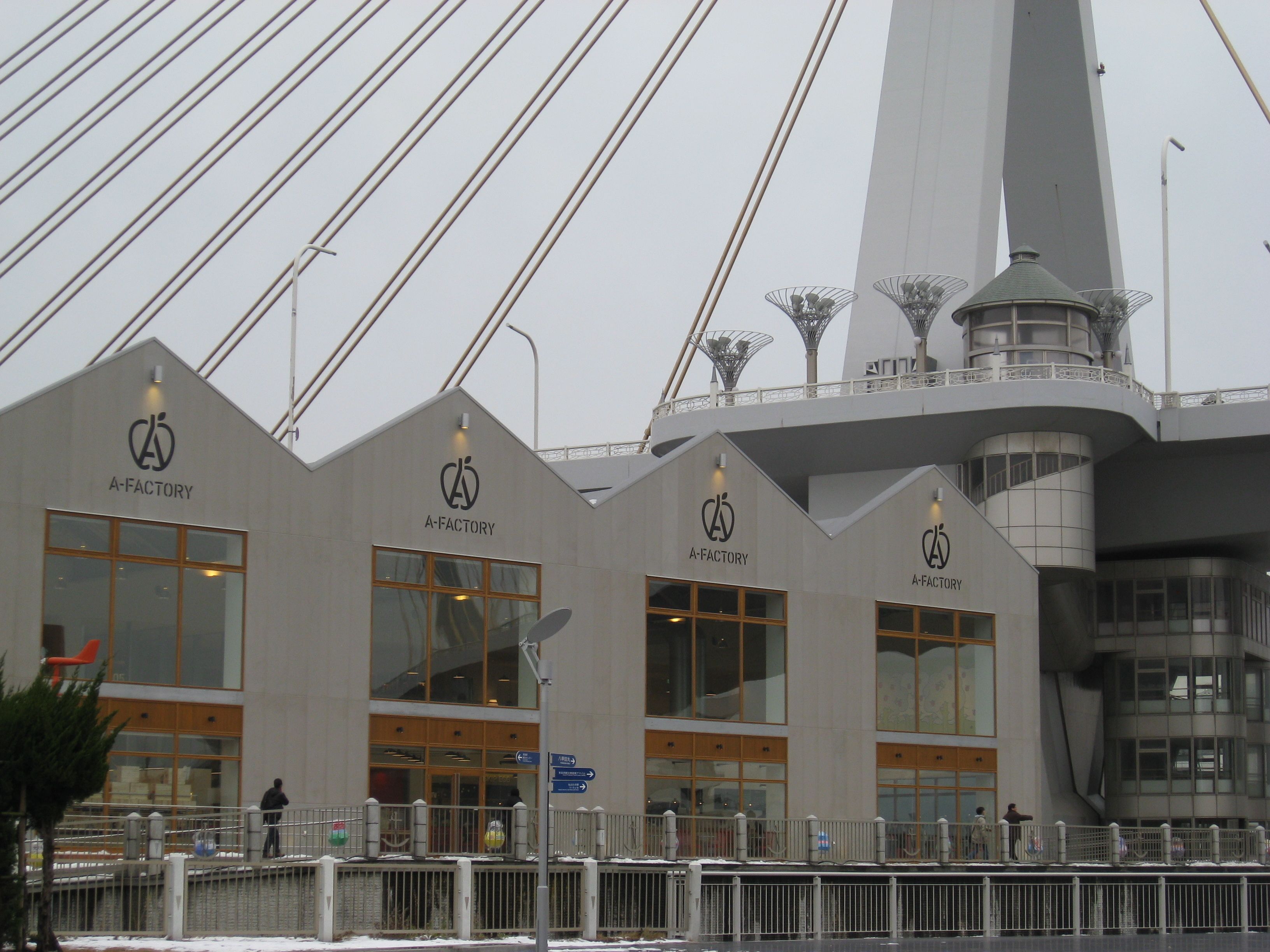 A modern building with the A-Factory logo, large windows, and a unique tower structure.