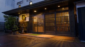 A traditional Japanese building with a wooden gate and a small garden area. - Yadoya Tsubaki (Aomori)