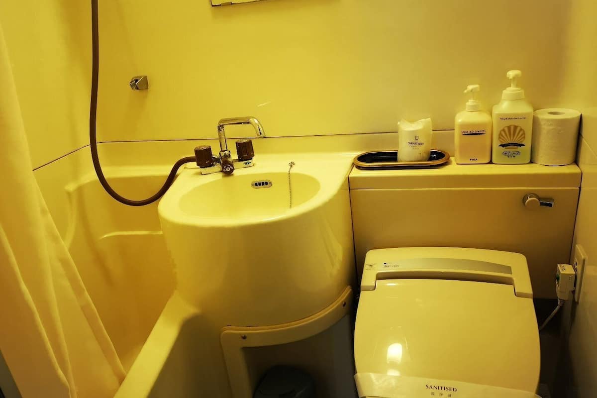 Une petite salle de bain comprenant un lavabo, des toilettes et des produits d’hygiène.