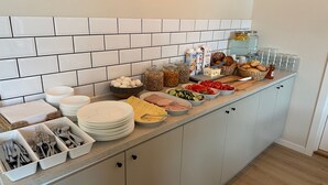 A breakfast buffet with various food items and utensils. - Vandrarhem Lidköping - Hostel (Lidköping)
