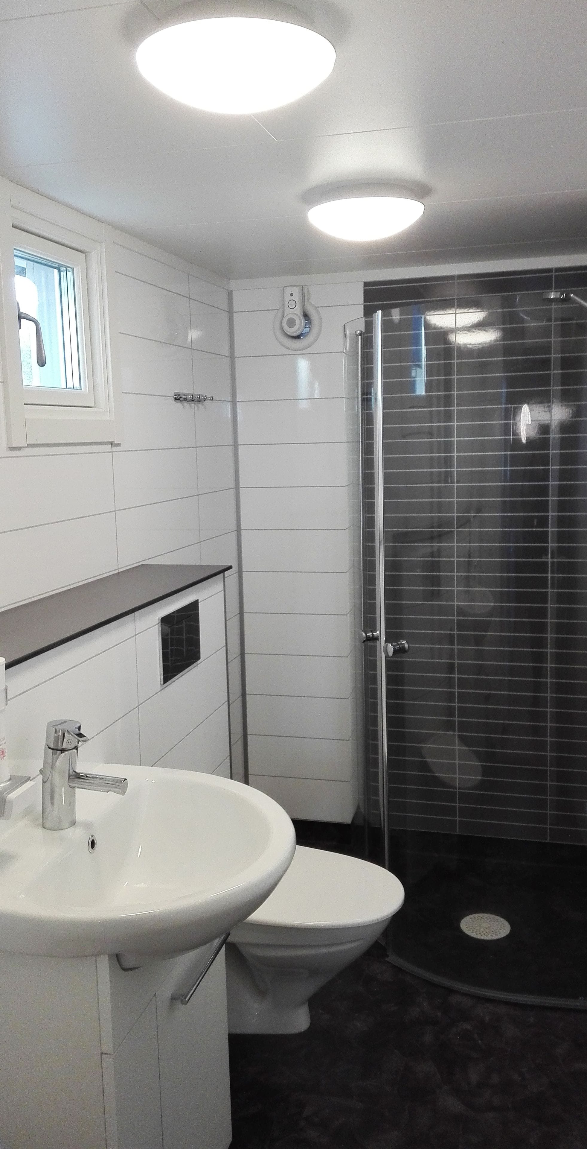 Ein modernes Badezimmer mit Waschbecken, Toilette und einer Duschkabine.