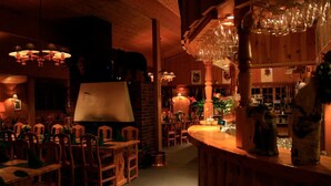 Ein gemütliches Restaurant mit Holztischen, einer Bar und hängenden Weingläsern.