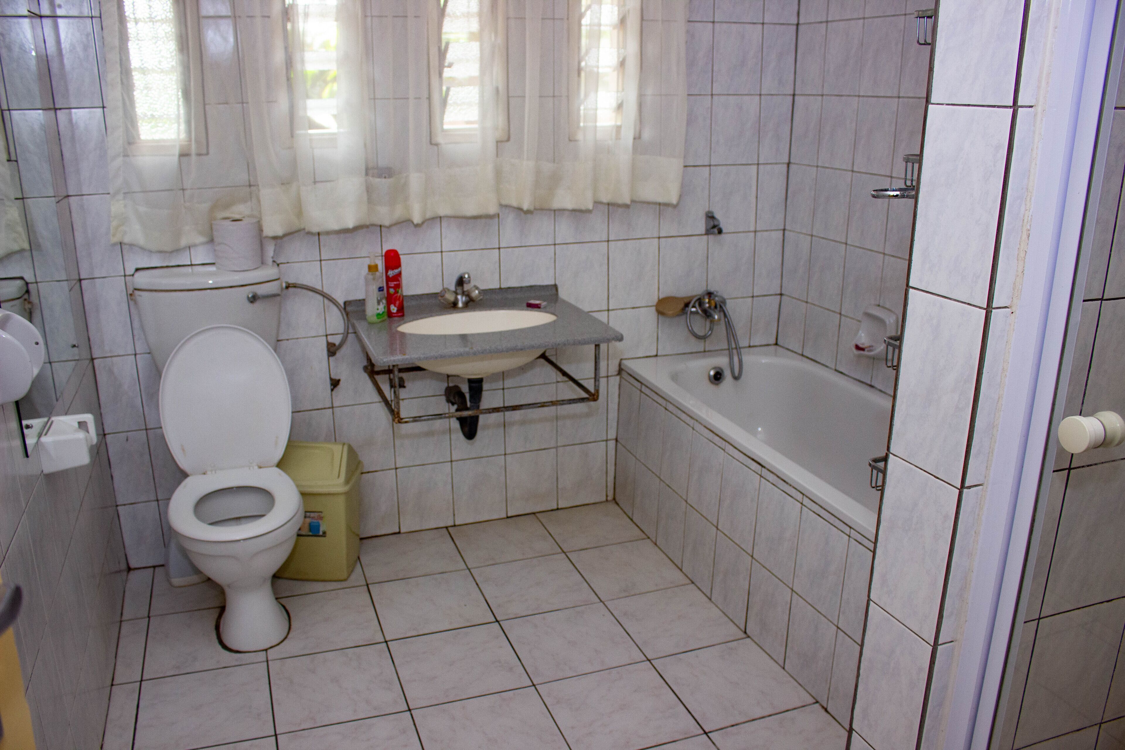 Un baño con inodoro, lavamanos, bañera y ducha.