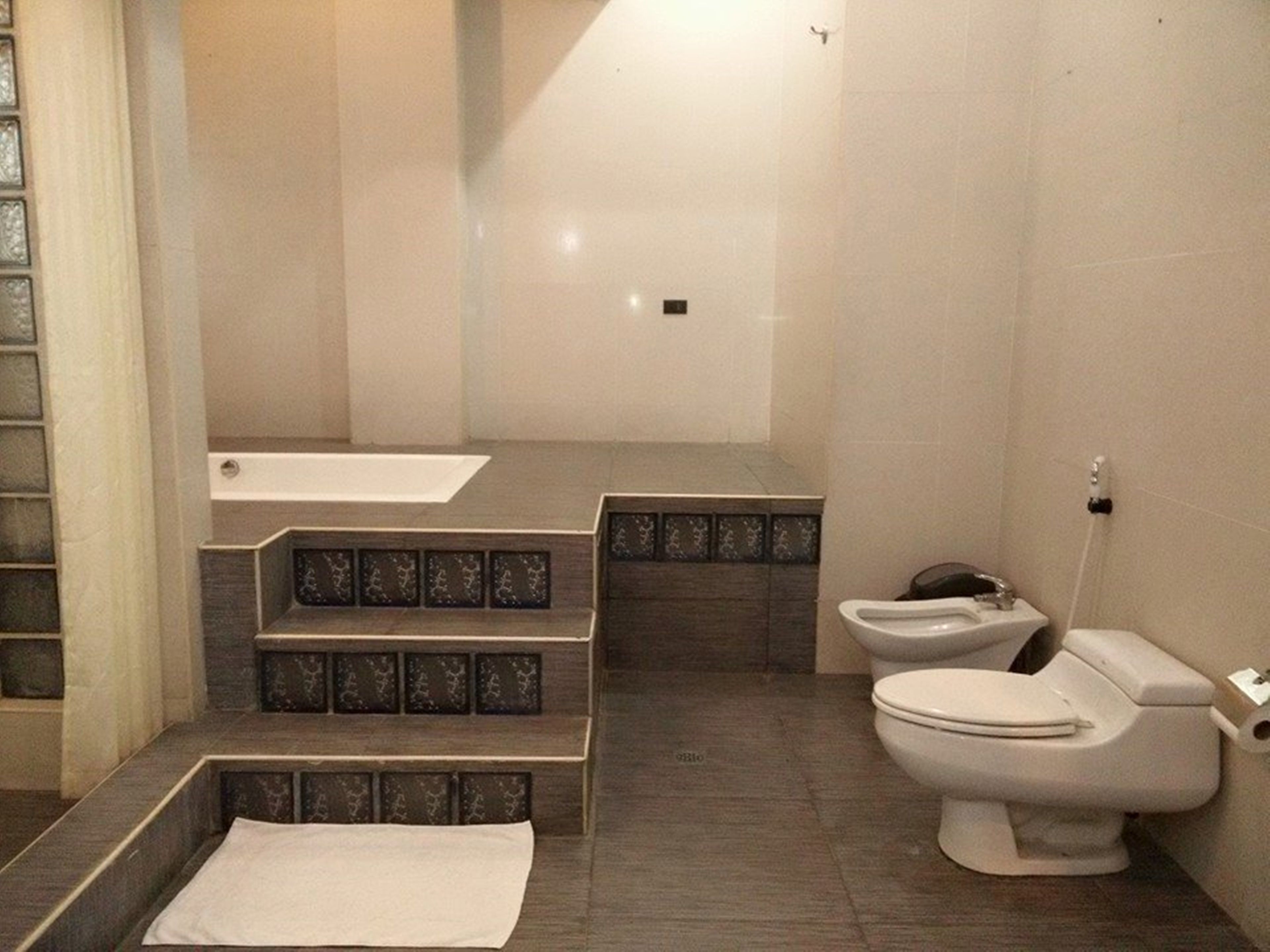 A bathroom with a bathtub, toilet, and a shower area.