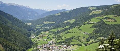 Une vallée où se trouve une petite ville, nichée au milieu de collines verdoyantes et de montagnes.