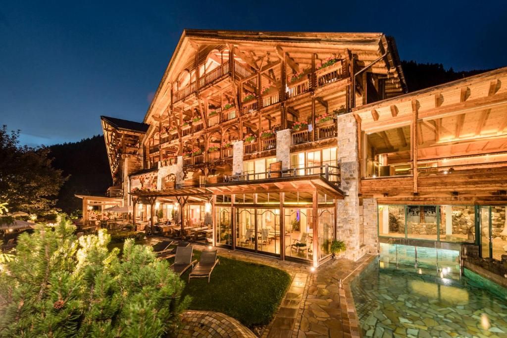 A multi-story wooden building with balconies and a glass-enclosed patio area.