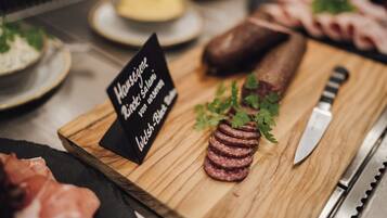 A wooden board with sliced salami, a knife, and a sign indicating 'Haugstygne' and 'Welsh-Black Salami'.