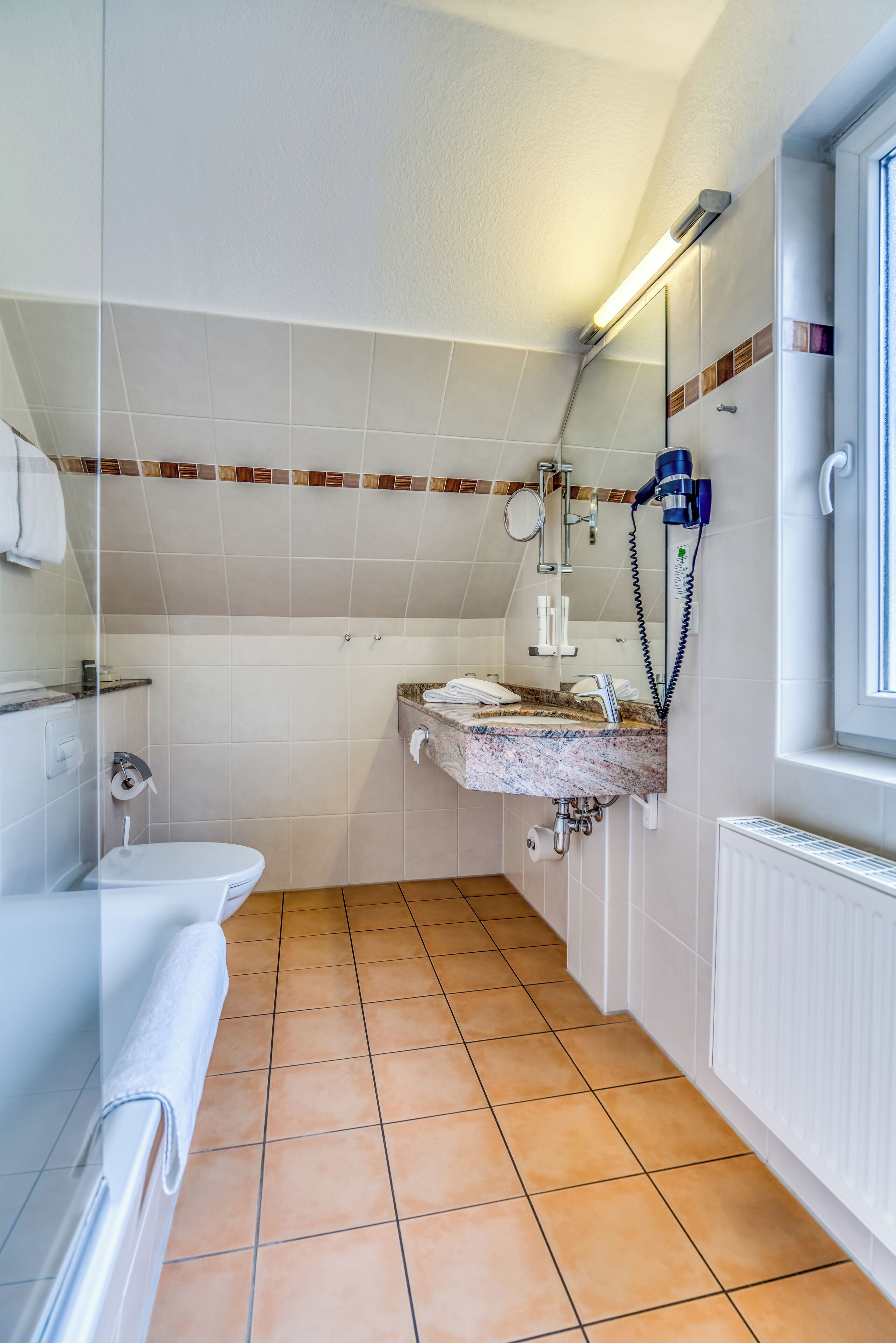 A bathroom with a toilet, sink, and shower.