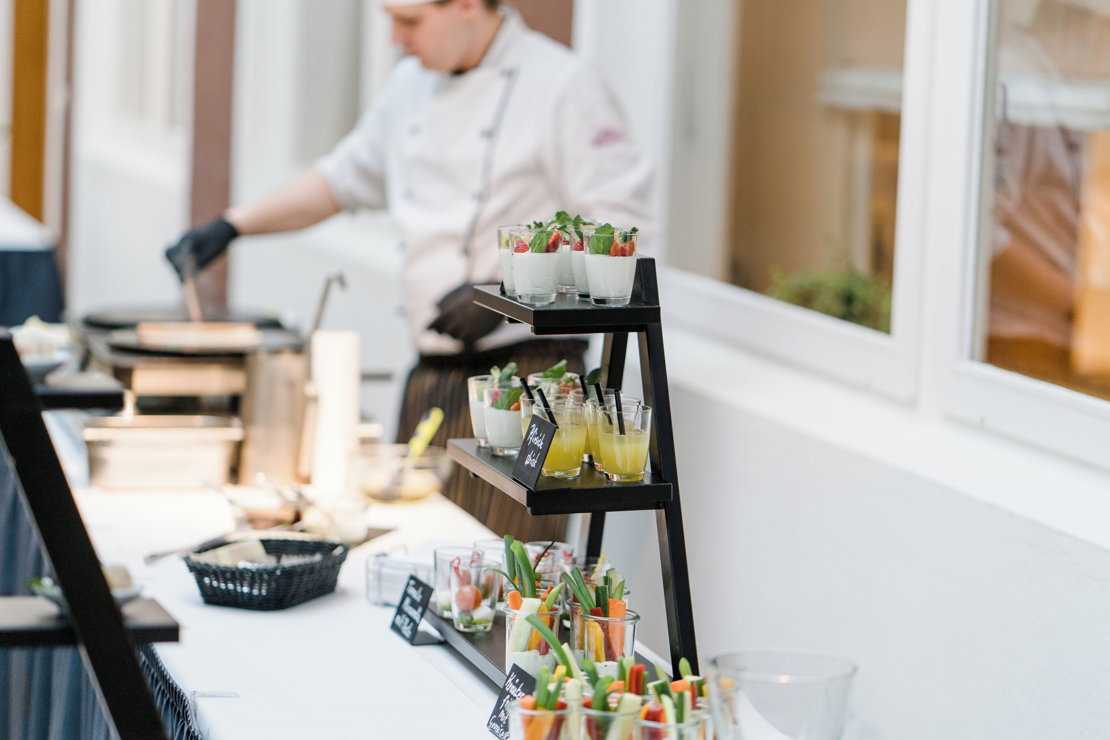 A buffet setup with various food items and drinks on a table.