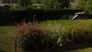 A rural landscape with a stone wall, a wooden fence, and a variety of vegetation. - Au Vieux Tilleul B&B (Les Trois Lacs)