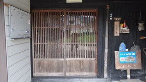 Ein traditionelles japanisches Tor mit Holzkonstruktion und einem Schild an der Wand.