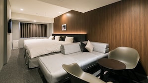 A modern hotel room with two beds, a sofa, a small table, and a TV. - Ginza Capital Hotel Moegi (Tokyo)