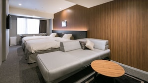 A modern hotel room with two beds, a sofa, a small table, and a TV. - Ginza Capital Hotel Moegi (Tokyo)
