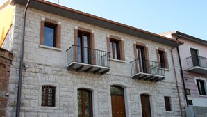 Un edificio de piedra de dos pisos con múltiples ventanas y balcones.