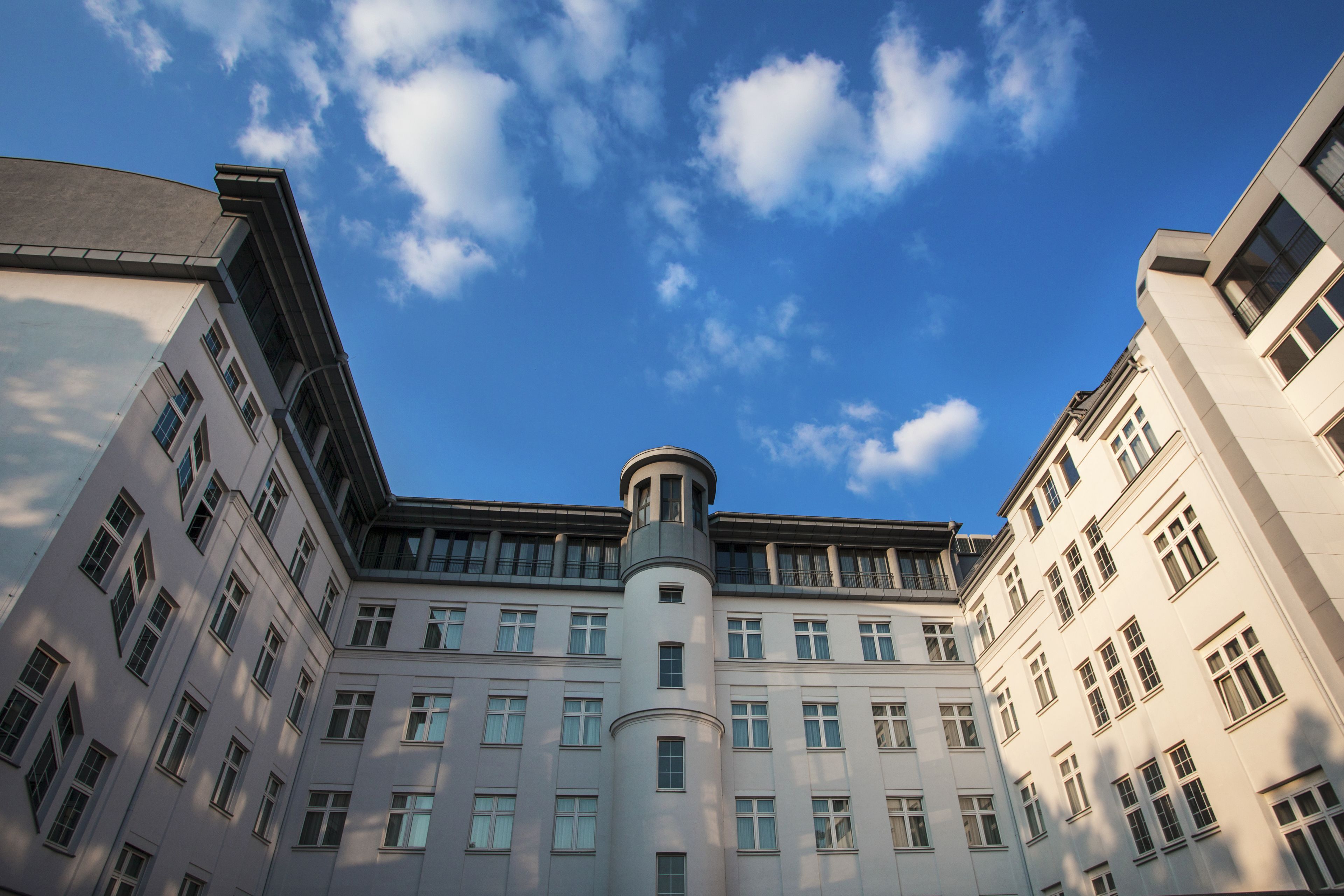 A multi-story building with a central tower, large windows, and a clear sky.