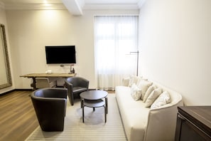 Relax in this stylish living room with a comfortable sofa, armchair, and flat-screen TV.