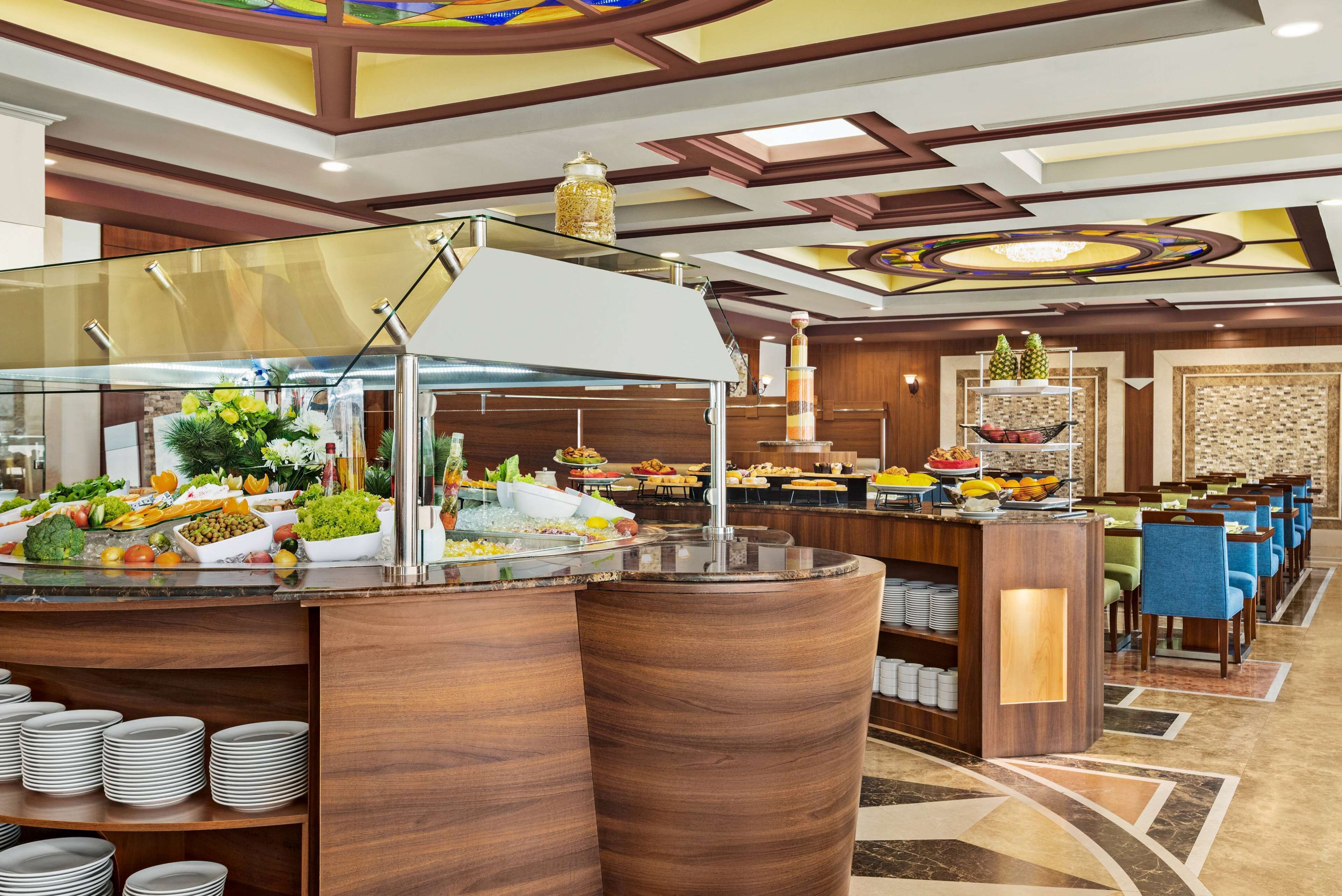 Zona de buffet con diferentes opciones de comida y una barra con platos.