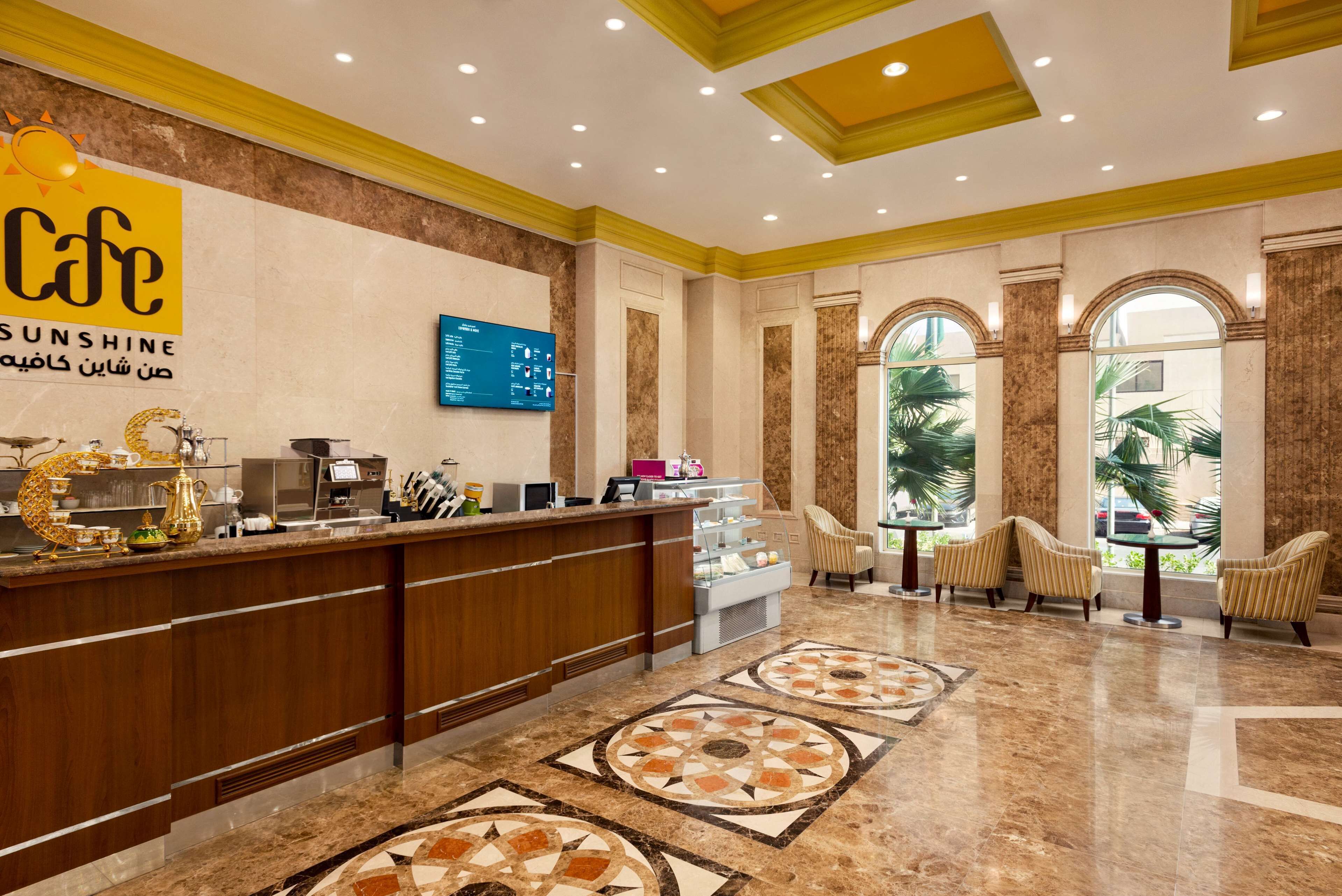 A hotel lobby with a reception desk, seating area, and decorative elements.