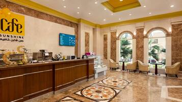 A hotel lobby with a reception desk, seating area, and decorative elements.