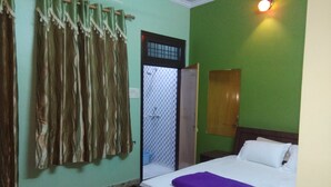 Een kamer met een bed, een kledingkast en een deur naar een badkamer.