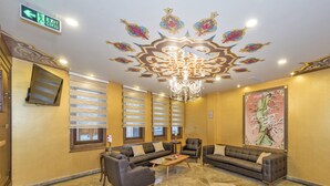 A lobby with a chandelier, sofas, a coffee table, and a painting on the wall. - Perapolis Hotel (Istanbul)