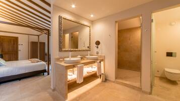 Un baño moderno con un espejo grande, dos lavamanos, ducha y retrete.