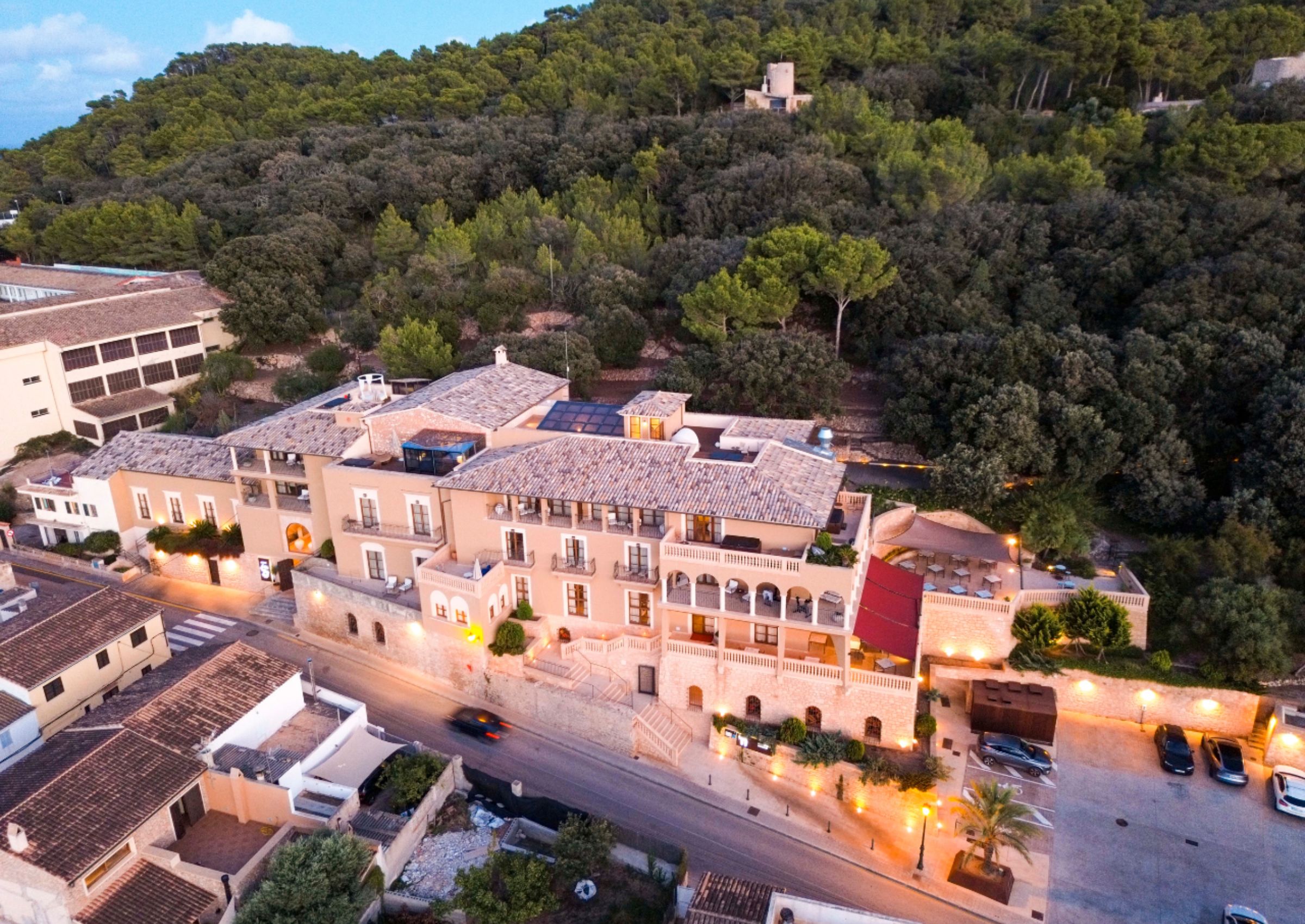Un hotel con varias edificaciones, una zona de estacionamiento y una carretera.