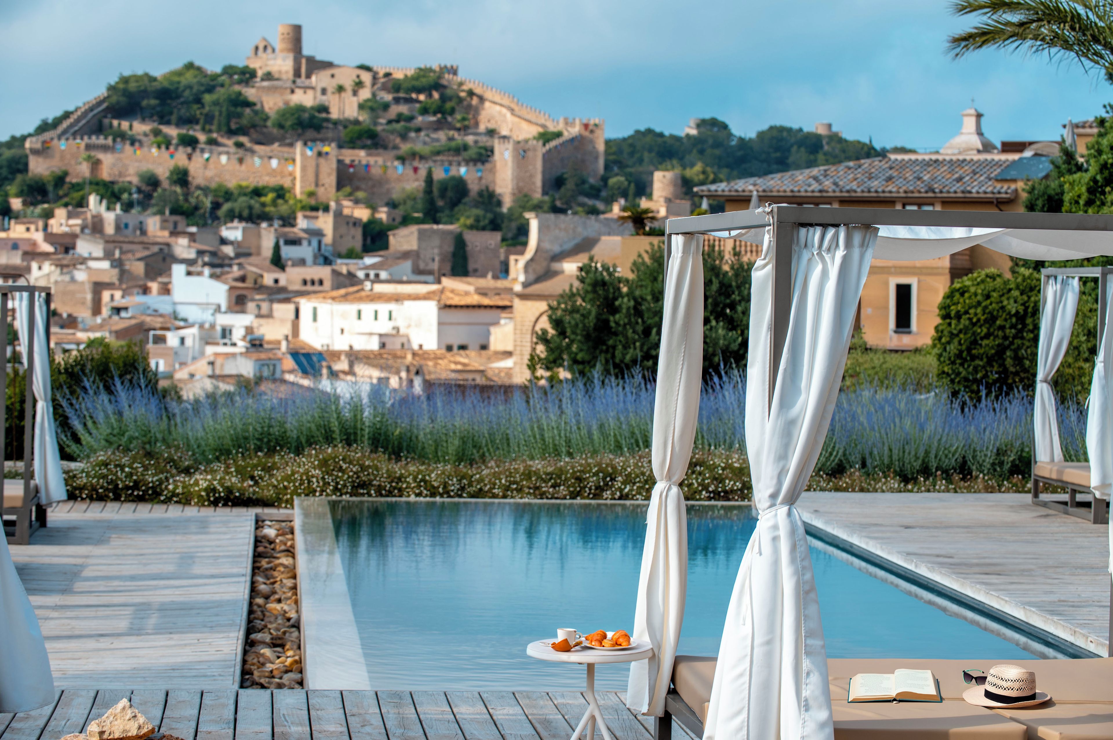 A poolside area with a view of a historic hilltop city.