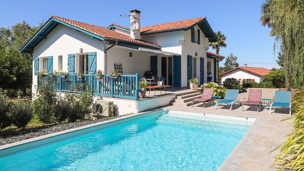 A two-story house with a swimming pool, a covered patio, and outdoor seating. - Chambre d'Hôtes Txori Etxea (Arcangues)