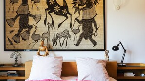 A bedroom with a bed, pillows, a nightstand, a lamp, and a bookshelf. - Chambre d'Hôtes Txori Etxea (Arcangues)