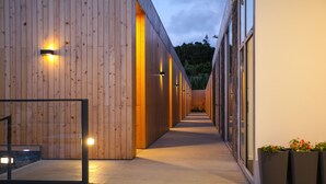 A modern building with wooden exterior walls and a long, straight corridor.