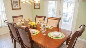 A dining table set with plates, glasses, and a centerpiece of lemons and flowers. - Ly58134 - Indian Ridge - 4 Bed 2 Baths Villa (Kissimmee)
