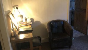 Een kamer met een bureau, stoel en een aan de muur bevestigde televisie.