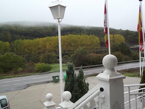 A view of a road with a guardrail, a lamp post, and flags. - La Montaña Palentina (Guardo)
