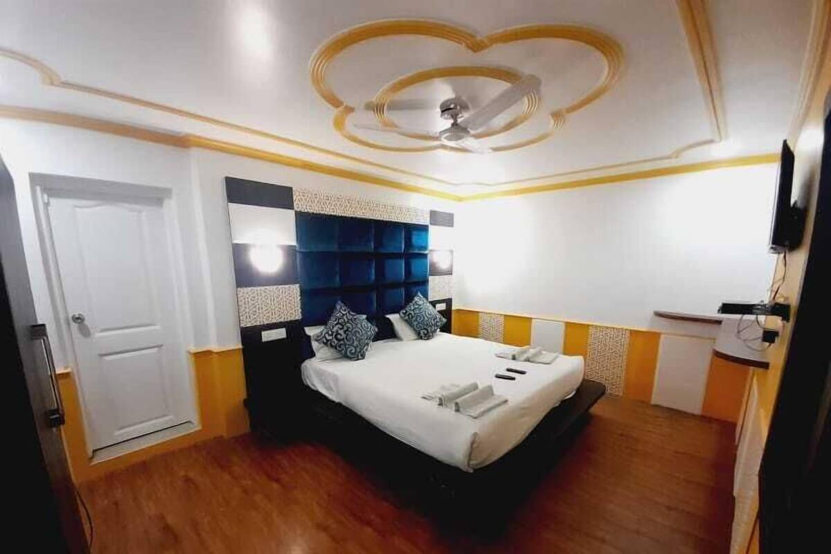 Quarto com cama, ventilador de teto e porta.