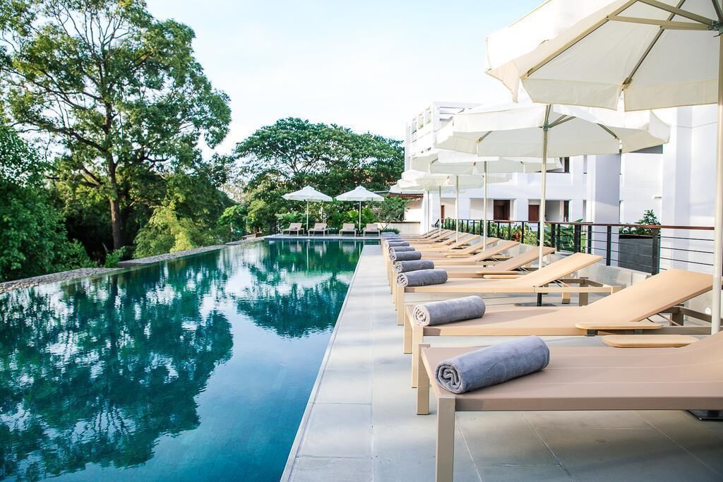 室外游泳池，06:00 至 22:00 开放，池畔遮阳伞，日光浴躺椅