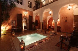 A courtyard with a pool, arches, and seating areas. - Dar Warda (Marrakech)