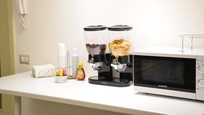 A kitchen counter with a coffee machine, a microwave, and various condiments. - B&B San Lorenzo (Benevento)