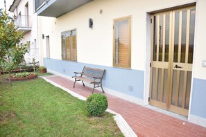 A building with a bench, a small garden, and a door with a metal gate. - B&B San Lorenzo (Benevento)